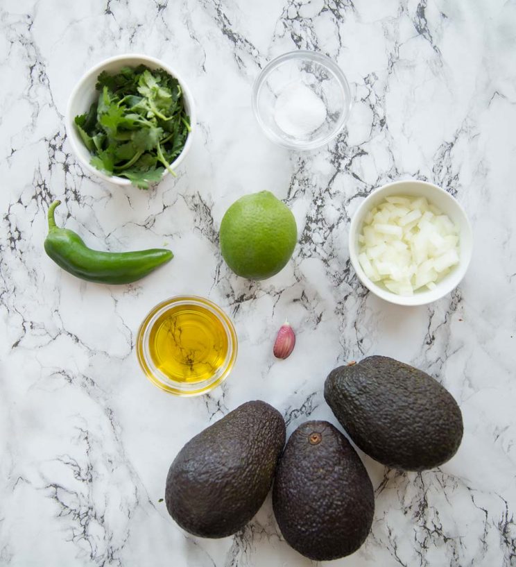 overhead shot of guacamole ingredients on marble background