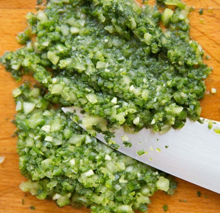 guacamole paste on chopping board with large knife