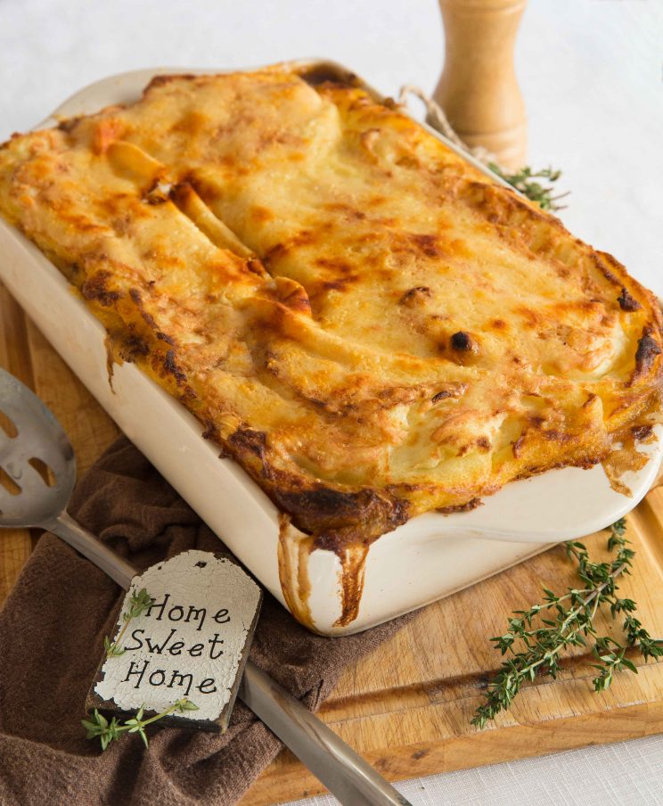 cottage pit served on wooden board with gravy dripping out of corners