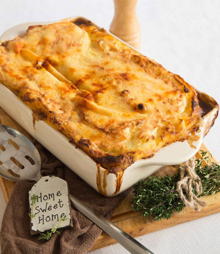 cottage pie fresh out the oven with beef dripping down edges of white casserole dish