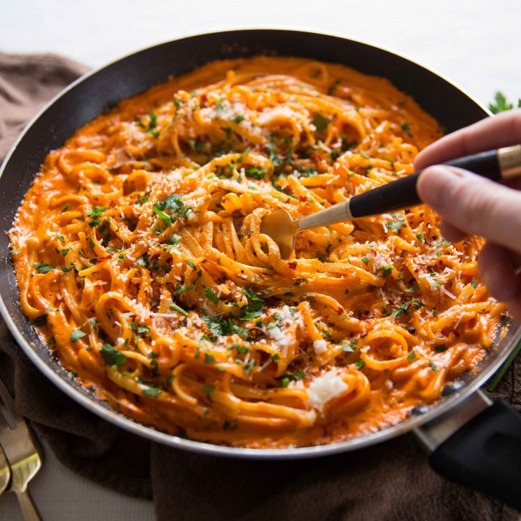 fork diving into skillet of pasta 