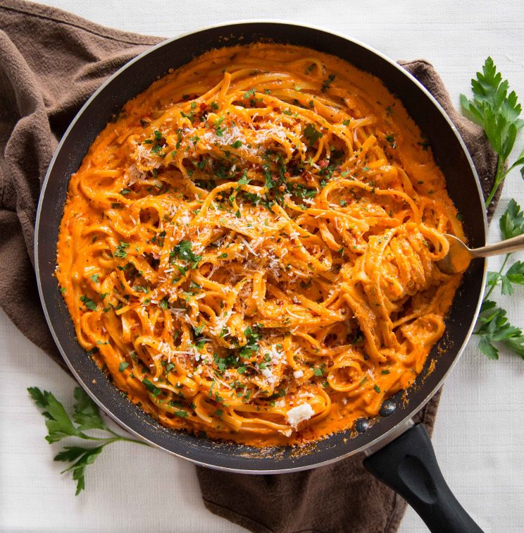 overhead shot of Creamy Roasted Red Pepper Pasta in skillet with fork diving in