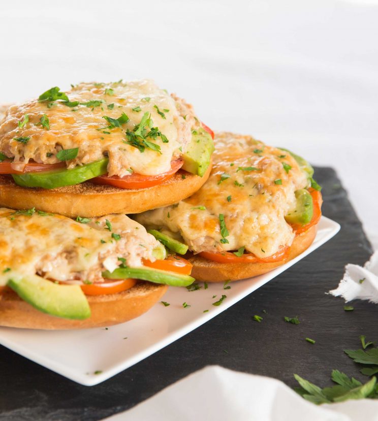 3 tuna bagels stacked on each other on square white plate