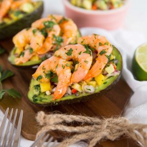 side shot of stuffed avocados lined up on chopping board