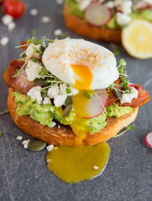 Cafe style smashed avocado on toast Yolk dripping down