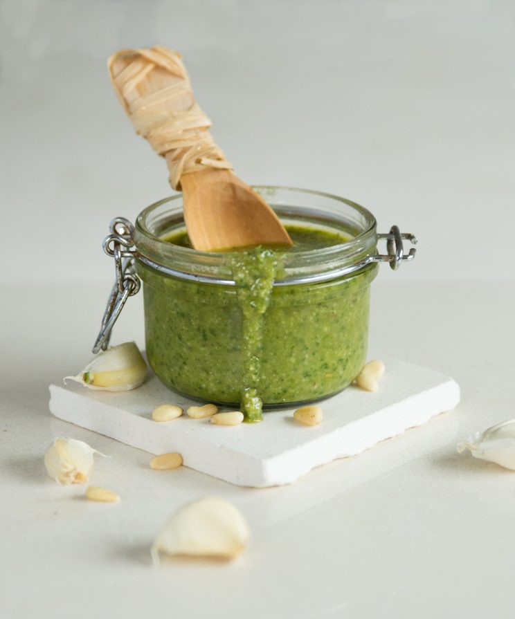 basil in glass jar with spoon inside and drip falling down jar