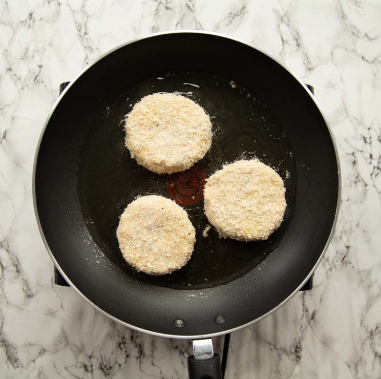 overhead shot of 3 patties frying in a skillet