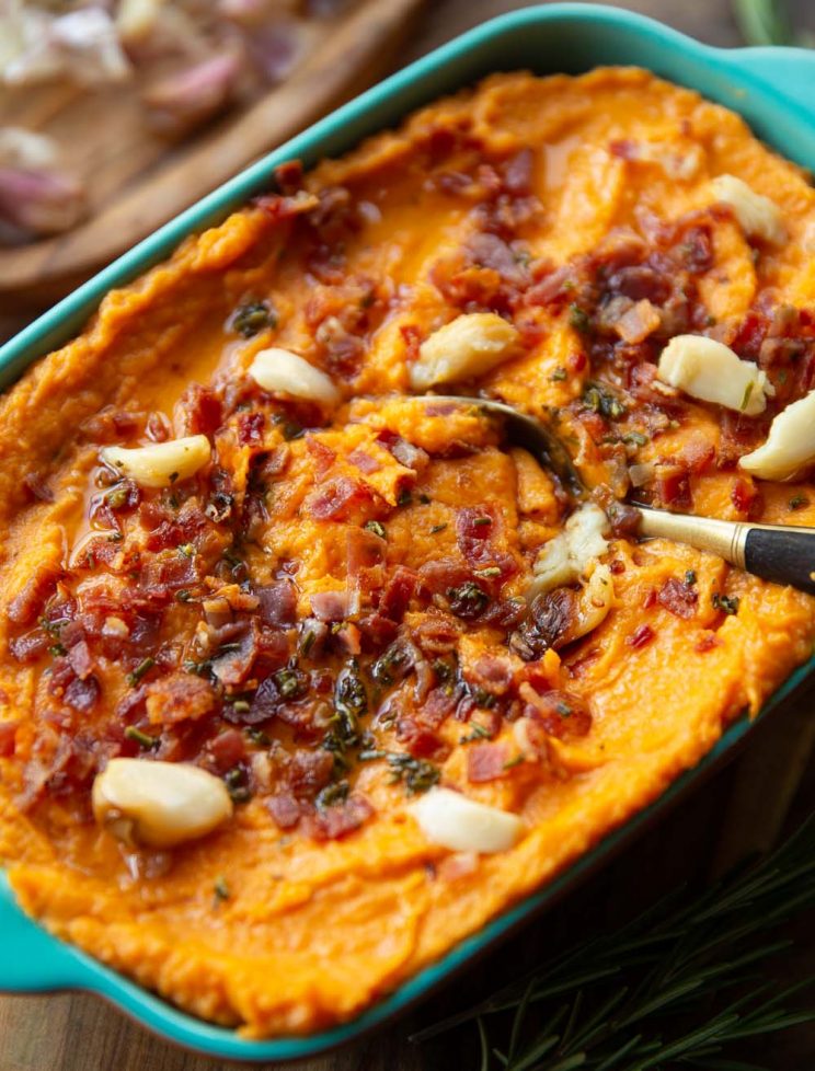 sweet potato mash in baking dish with golden spoon digging in