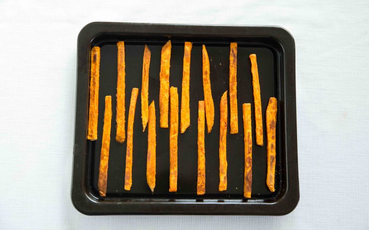 overhead shot of sweet potato fries on baking tray post oven