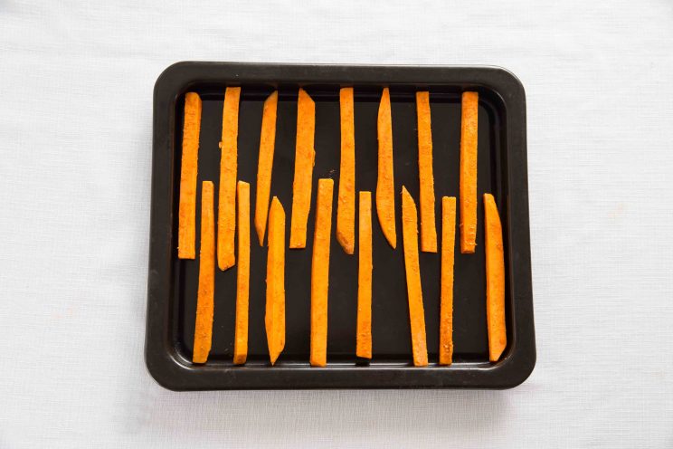 overhead shot of sweet potato fries on baking tray pre oven