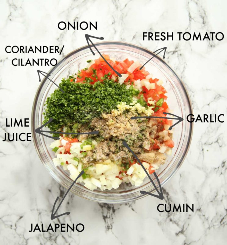 overhead shot of salsa ingredients in glass bowl with labels