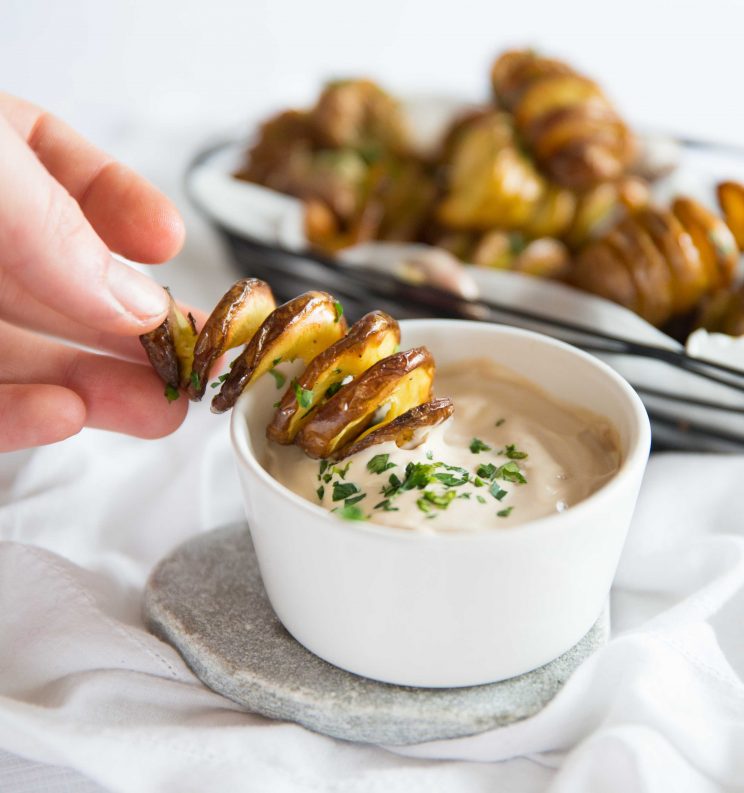 hand mini tornado fry into small white pot of dip