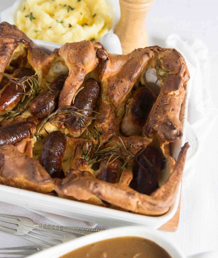 side shot of Toad in the Hole with jug of Gravy ready to pour