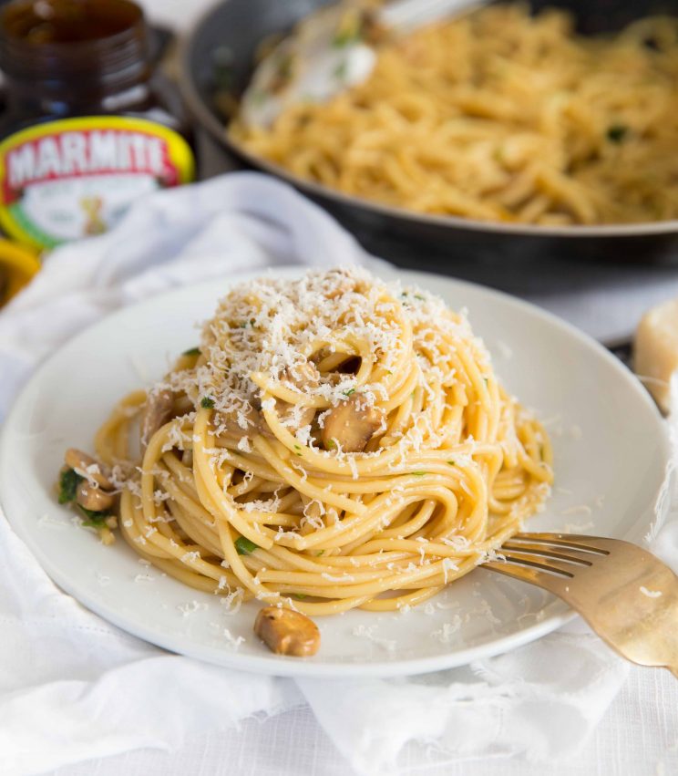 Marmite Pasta sprinkled with Parmesan Cheese with Jar of Marmite in the background