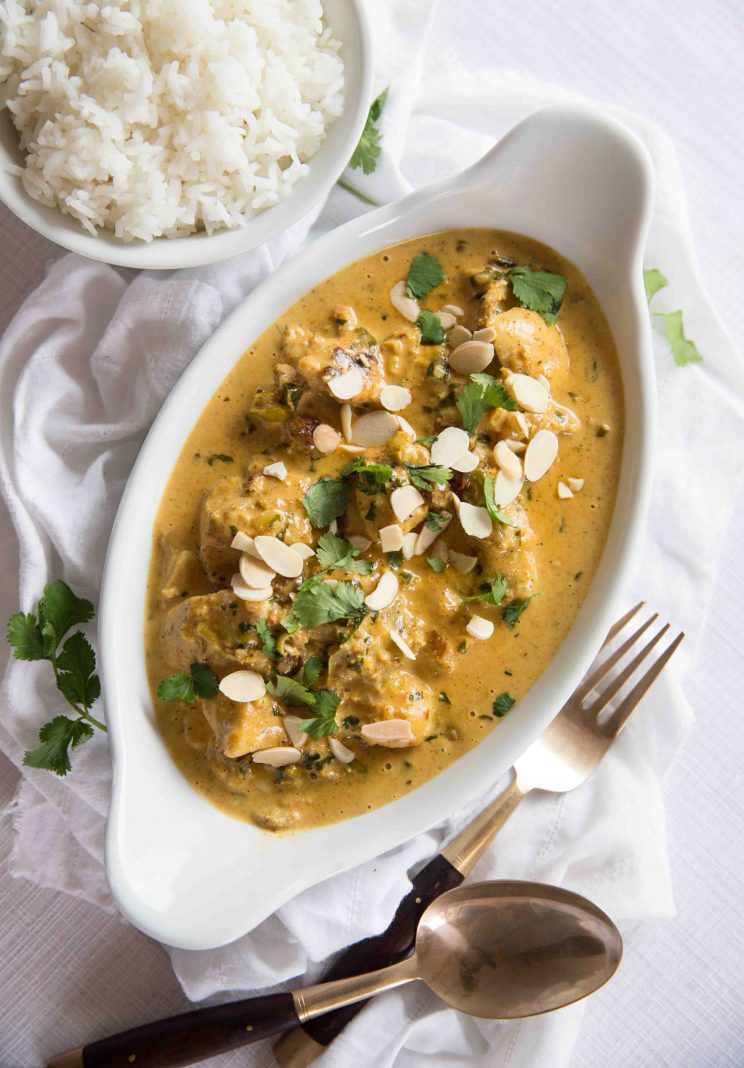 overhead shot of curry in oval shaped bowl on white sheet