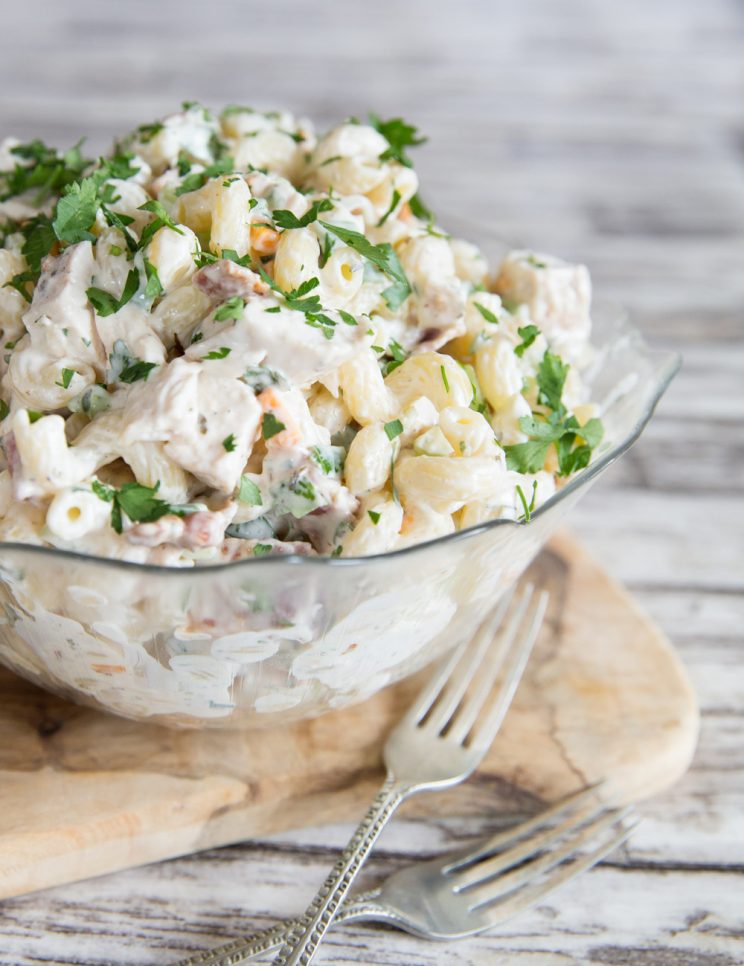 Chicken Bacon Ranch Pasta Salad with fresh parsley in a glass bowl