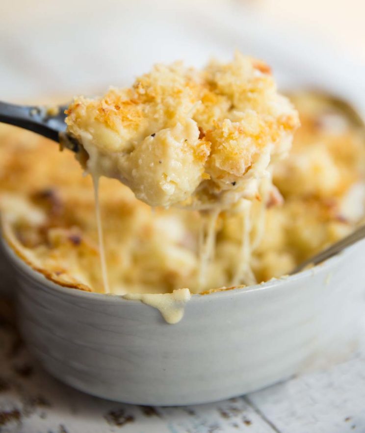 Gnocchi Mac and Cheese with scooped out of baking dish with cheese pull