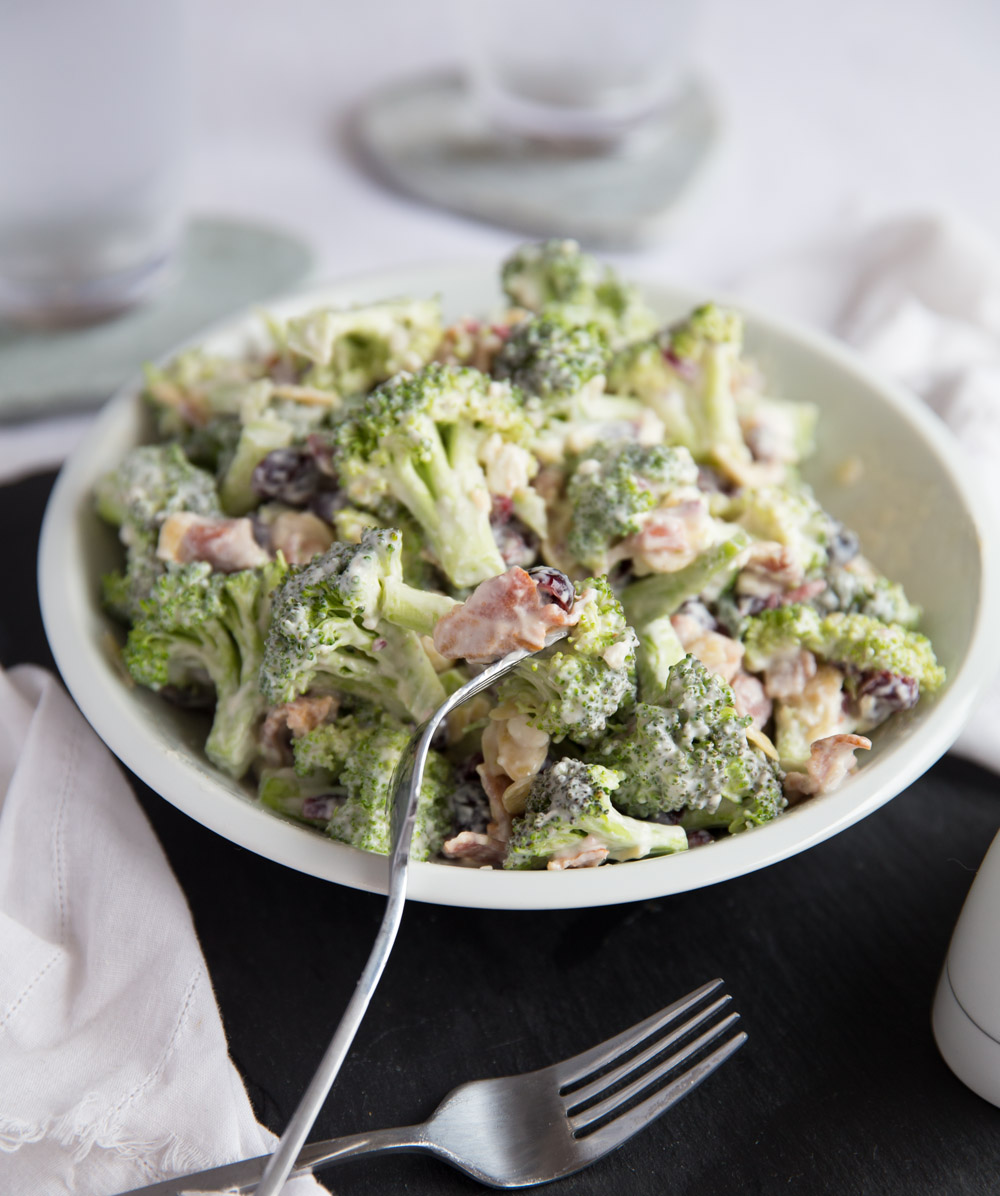 broccoli salad in large white dish with silver forks