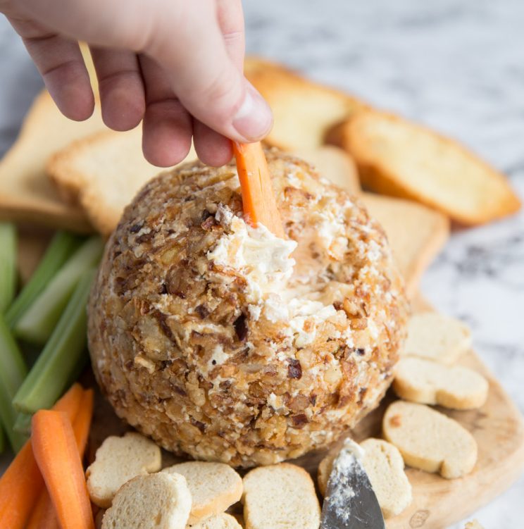 dipping a carrot into cheese ball