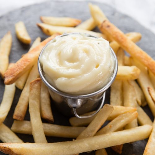 small silver pot of aioli with fries surrounding it