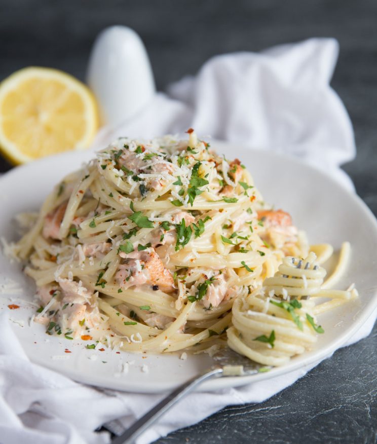 Salmon Pasta garnished with chilli flakes and parmesan