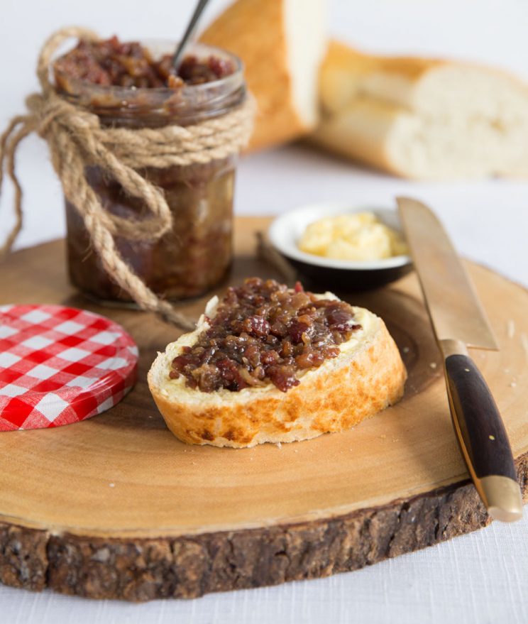 Bacon Jam on bread and butter with baguette blurred in the background