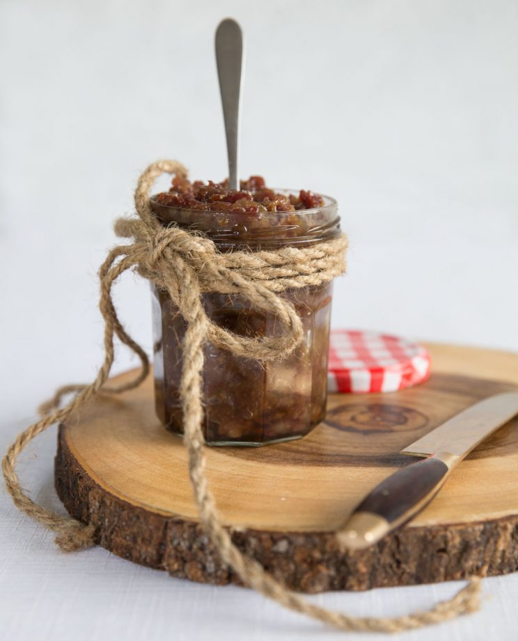 Canned Bacon Jam with the lid off on wooden block