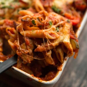 closeup shot of scooping pasta bake out of oven dish