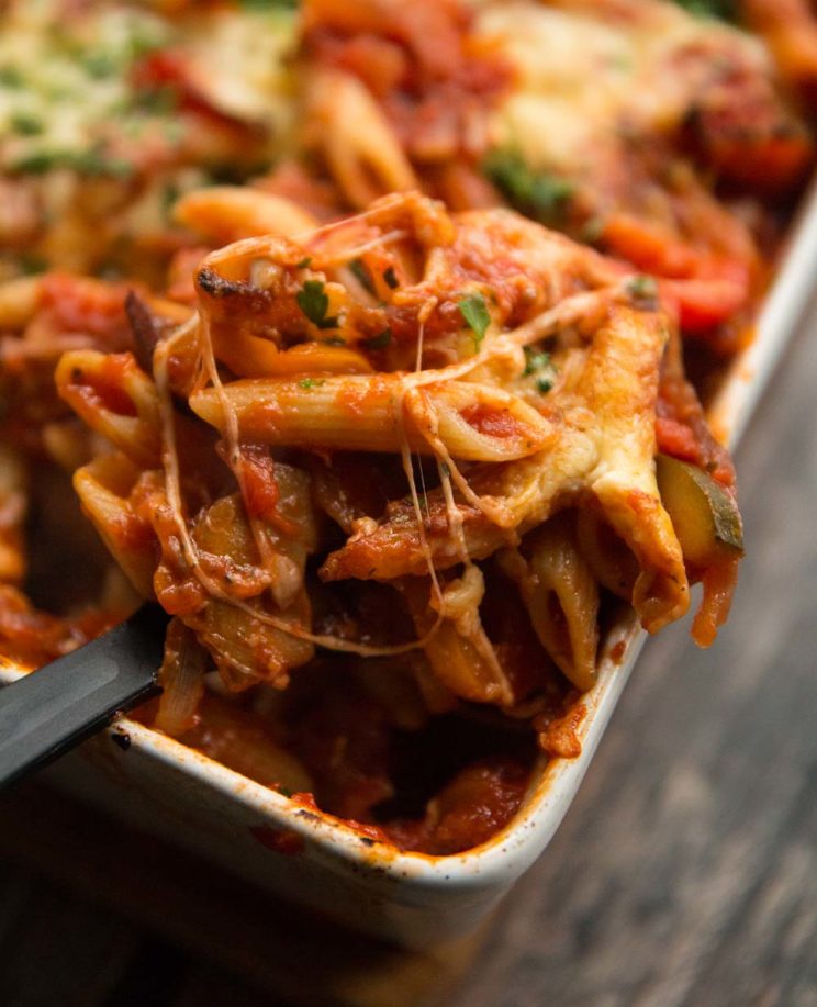 closeup shot of scooping pasta bake out of oven dish