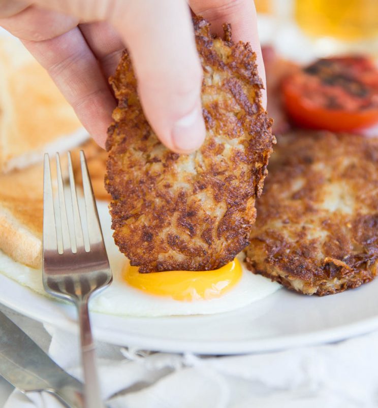 dunking hash brown into sunny side up fried egg