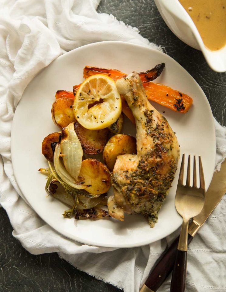 overhead shot of Herb Roasted Spatchcock Chicken with served with Homemade Chicken Gravy with lemon wedge