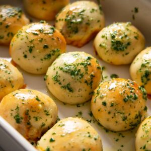 close up shot of leftover chilli dough balls fresh out the oven in large white dish