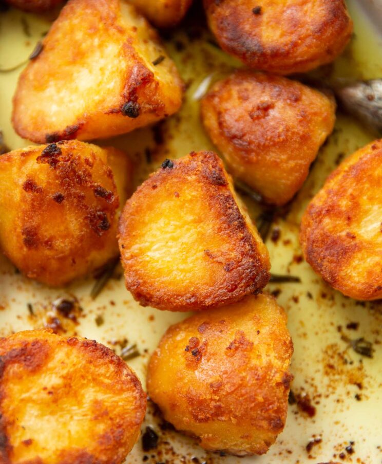 close up shot of potatoes roasted in goose fat in baking dish fresh out the oven