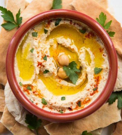 Bowl of hummus garnished with olive oil and paprika