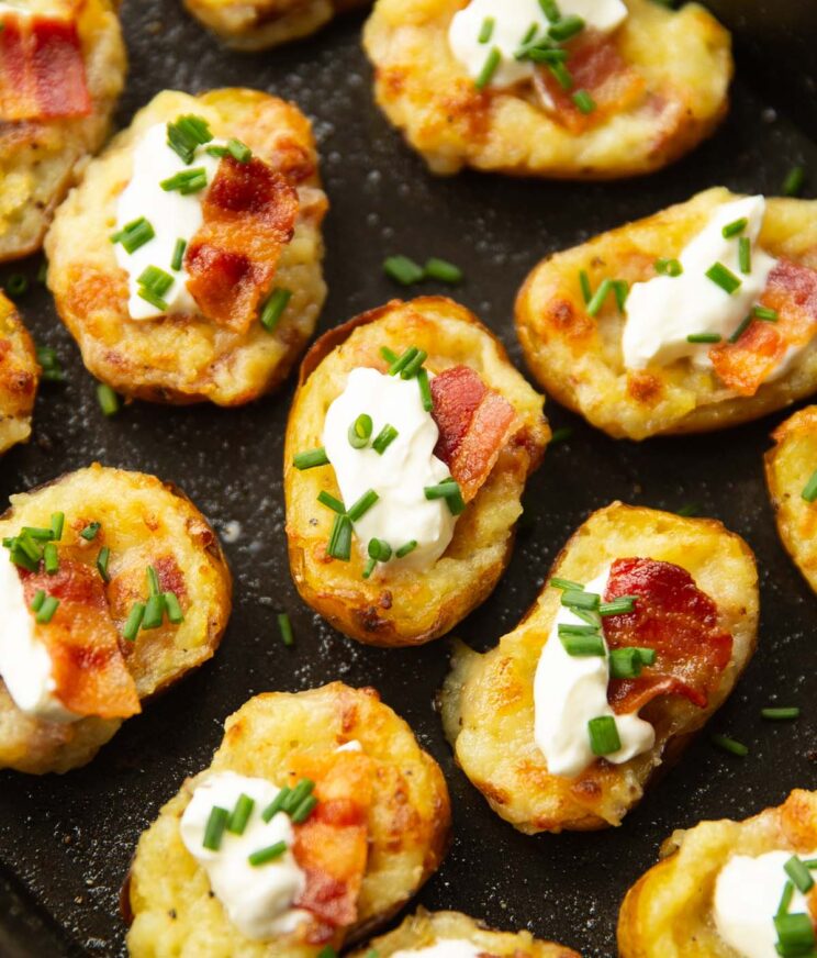 close up shot of mini loaded potatoes on black oven tray