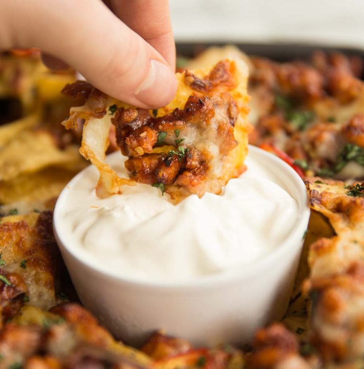 Dipping Nacho into Pot of Sour Cream