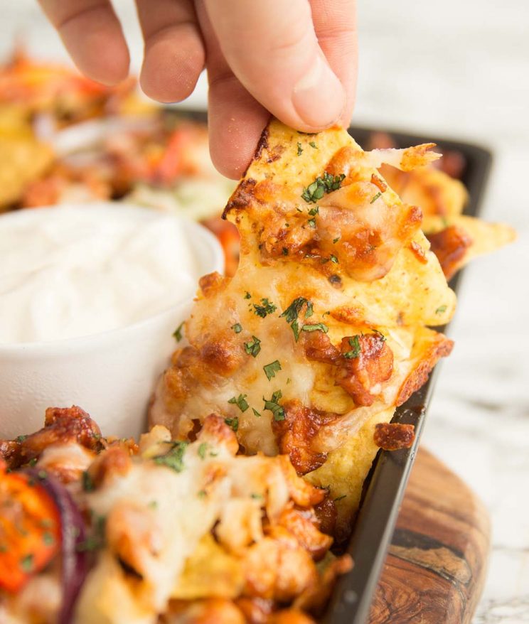 hand pulling tortilla off of tray with cheese pull