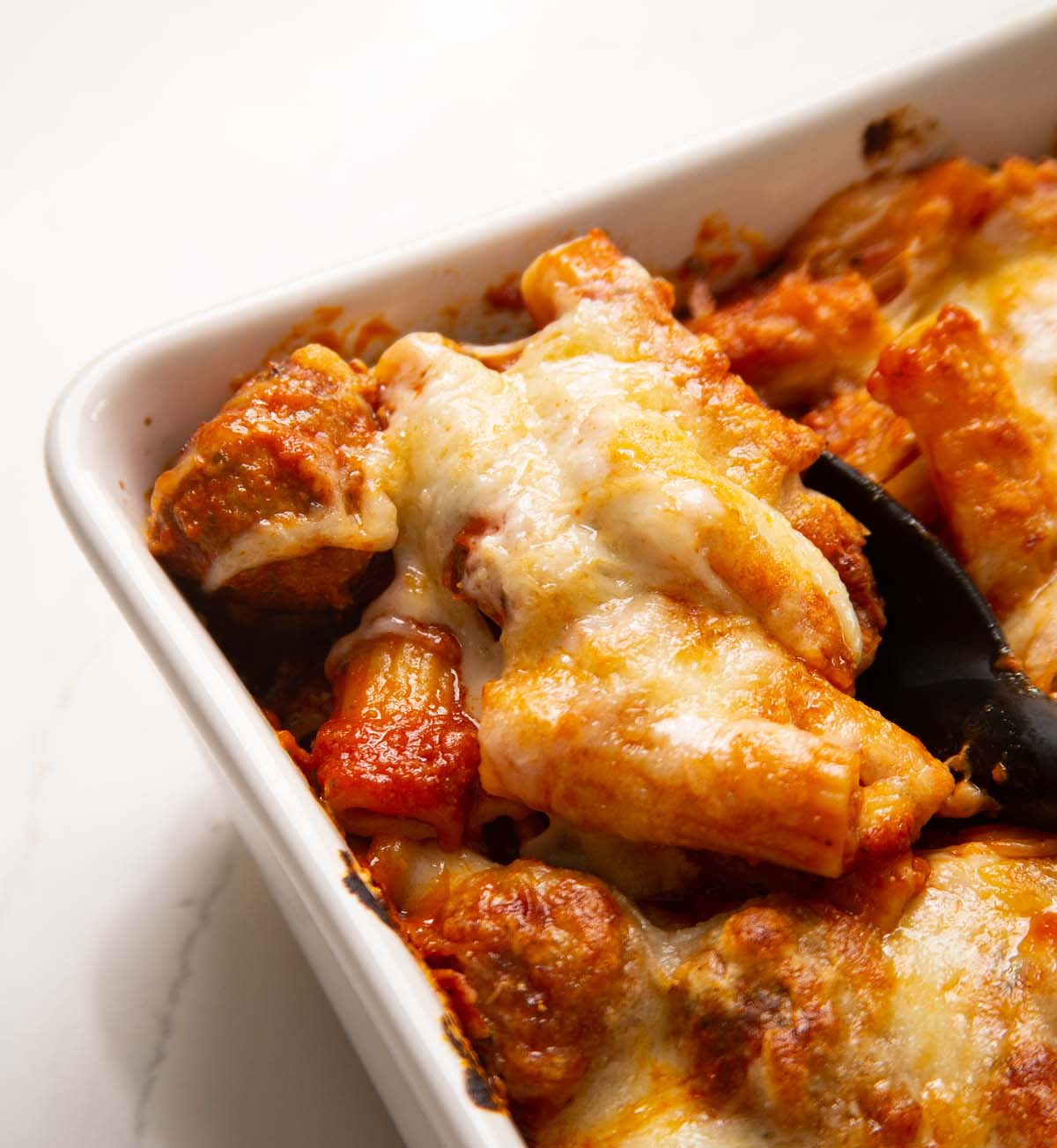 close up shot of meatball pasta bake in baking dish
