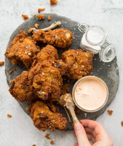 Crispy Buttermilk Fried Chicken on a grey slate with dip and salt