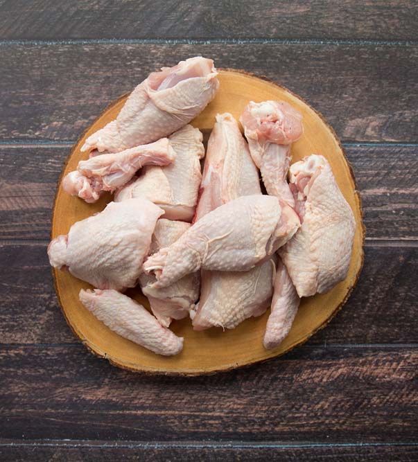 Whole chicken cut into 12 pieces Whole chicken cut into 12 pieces on a wooden board