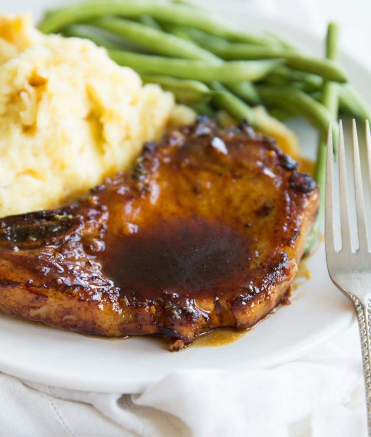 One Honey Garlic Pork Chop served on a plate with mash and green beans