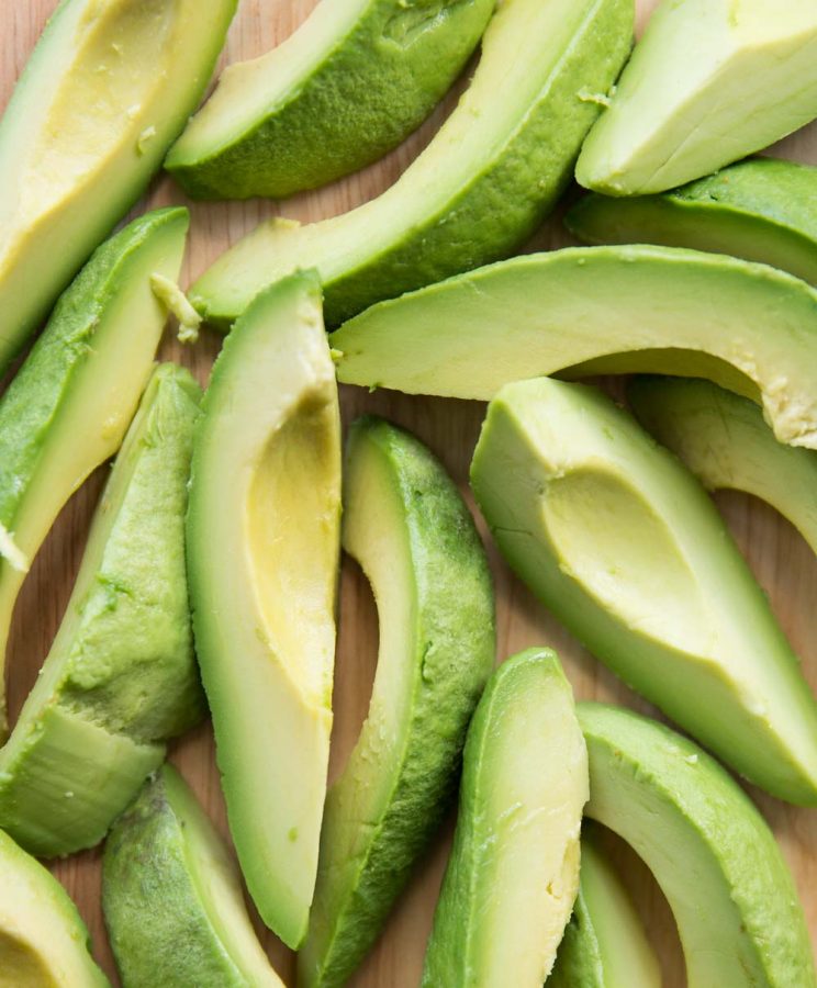 Overhead shot of sliced avocado on chopping board