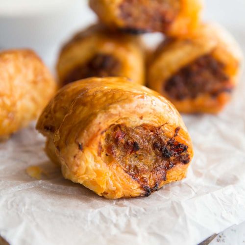 Pork and Chorizo Sausage Roll on baking paper with 4 in the background