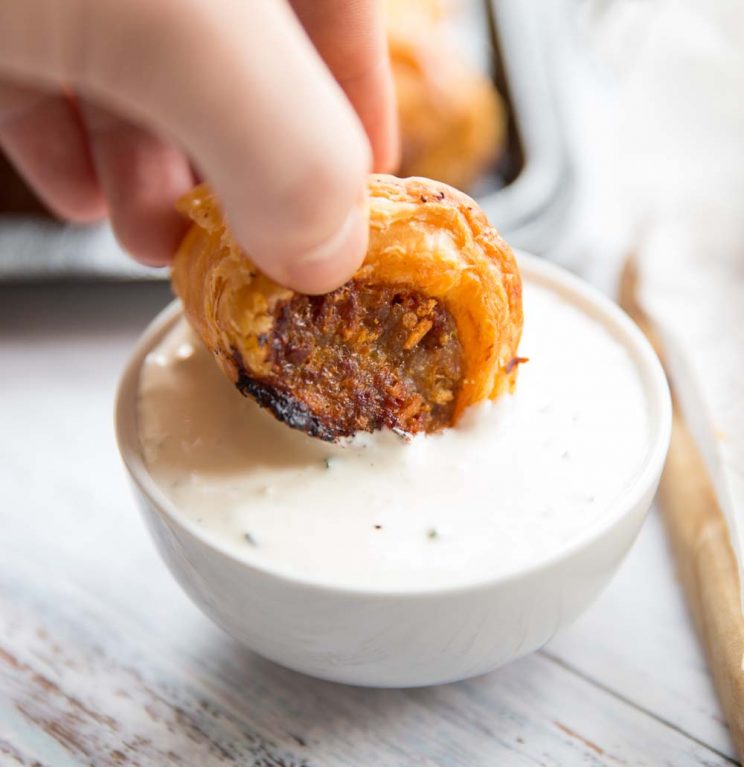 dipping a chorizo sausage roll into cheese and chive dip