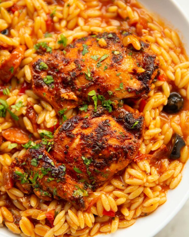 spanish chicken and orzo served in large white bowl