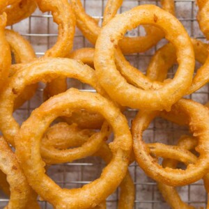 overhead shot of onion rings scattered across a wire rack