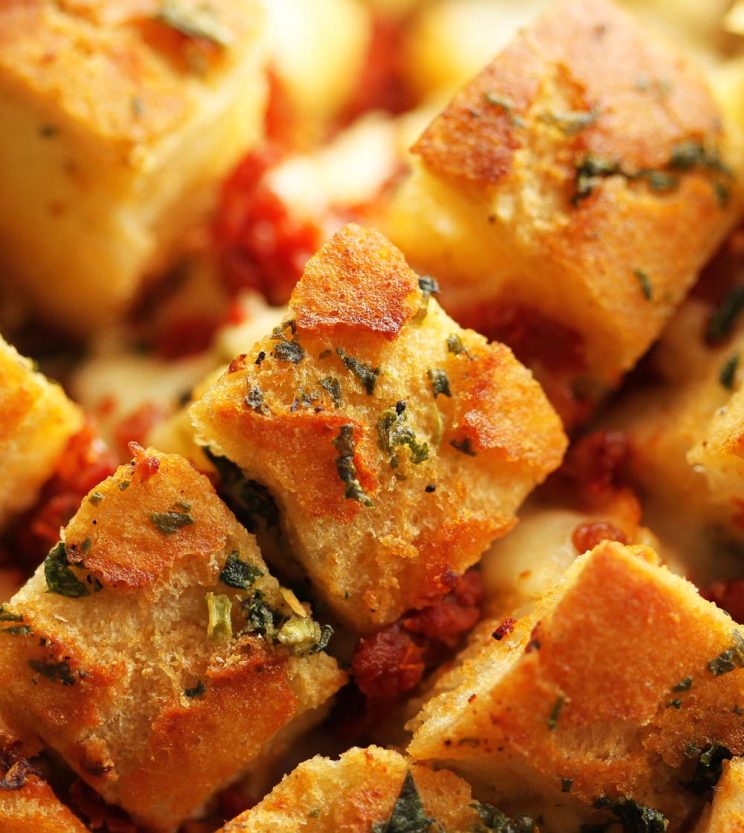 closeup of pull apart bread with focus on finely chopped basil