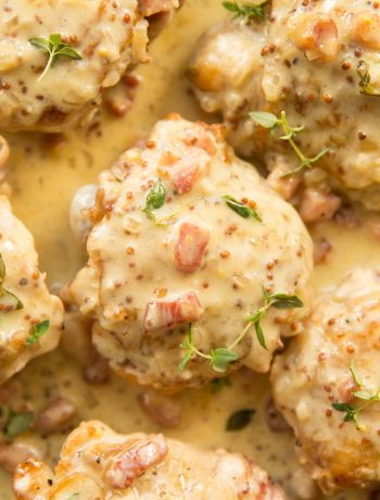 overhead shot of thighs and sauce in a skillet garnished with fresh thyme