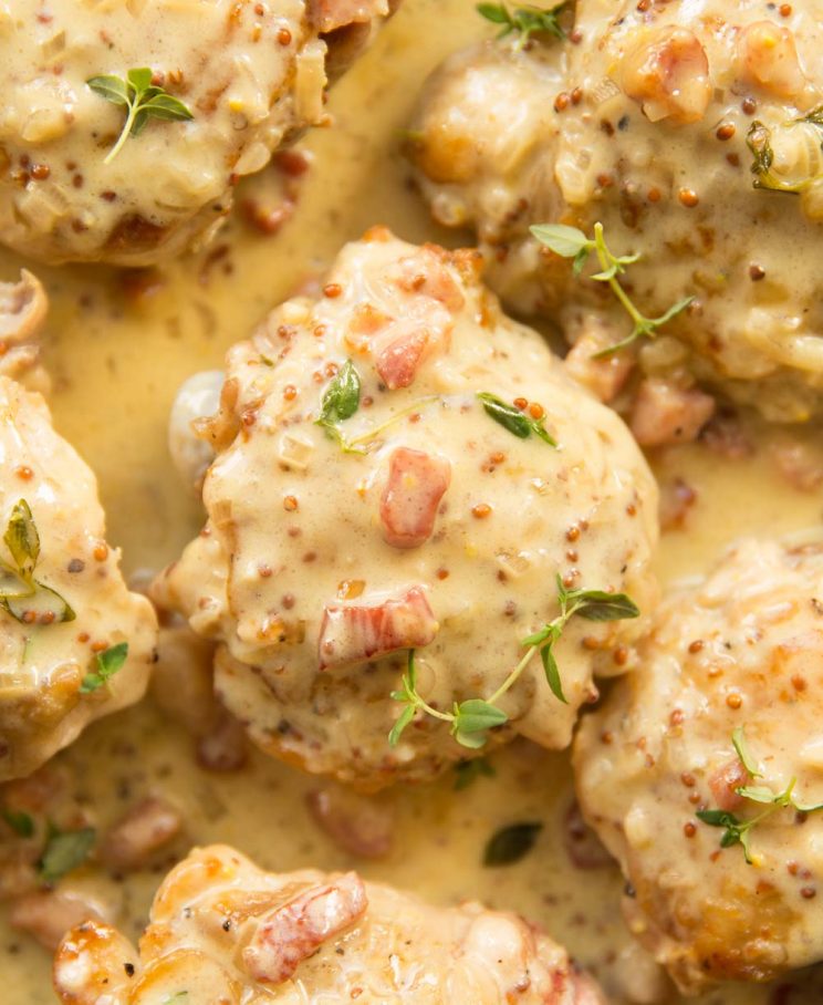 overhead shot of thighs and sauce in a skillet garnished with fresh thyme
