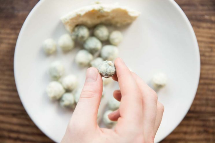 overhead shot of holding a blue cheese ball with more blurred in the background